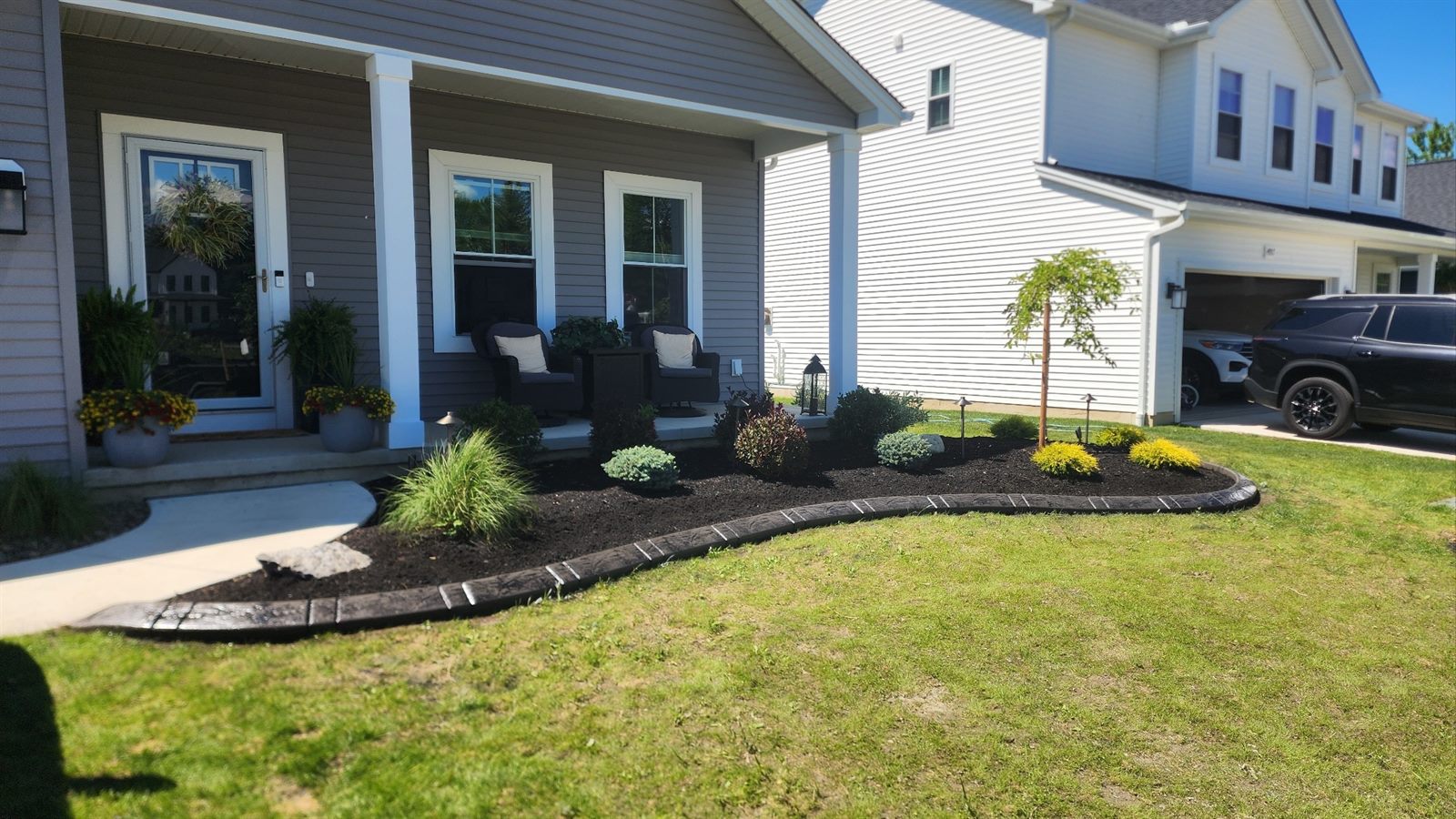 Decorative concrete curbing along a front porch bed