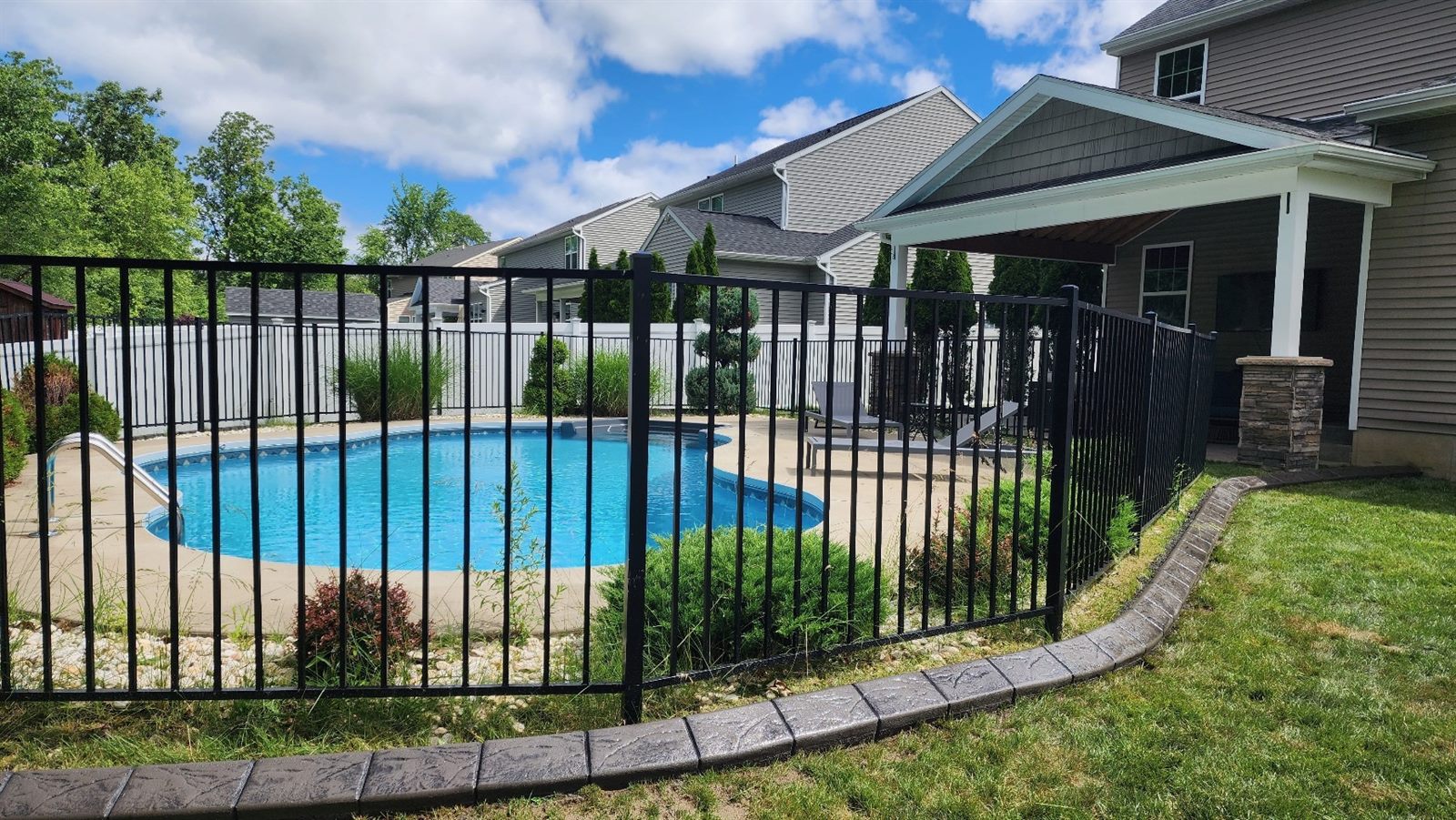 Decorative curbing along a pool fence