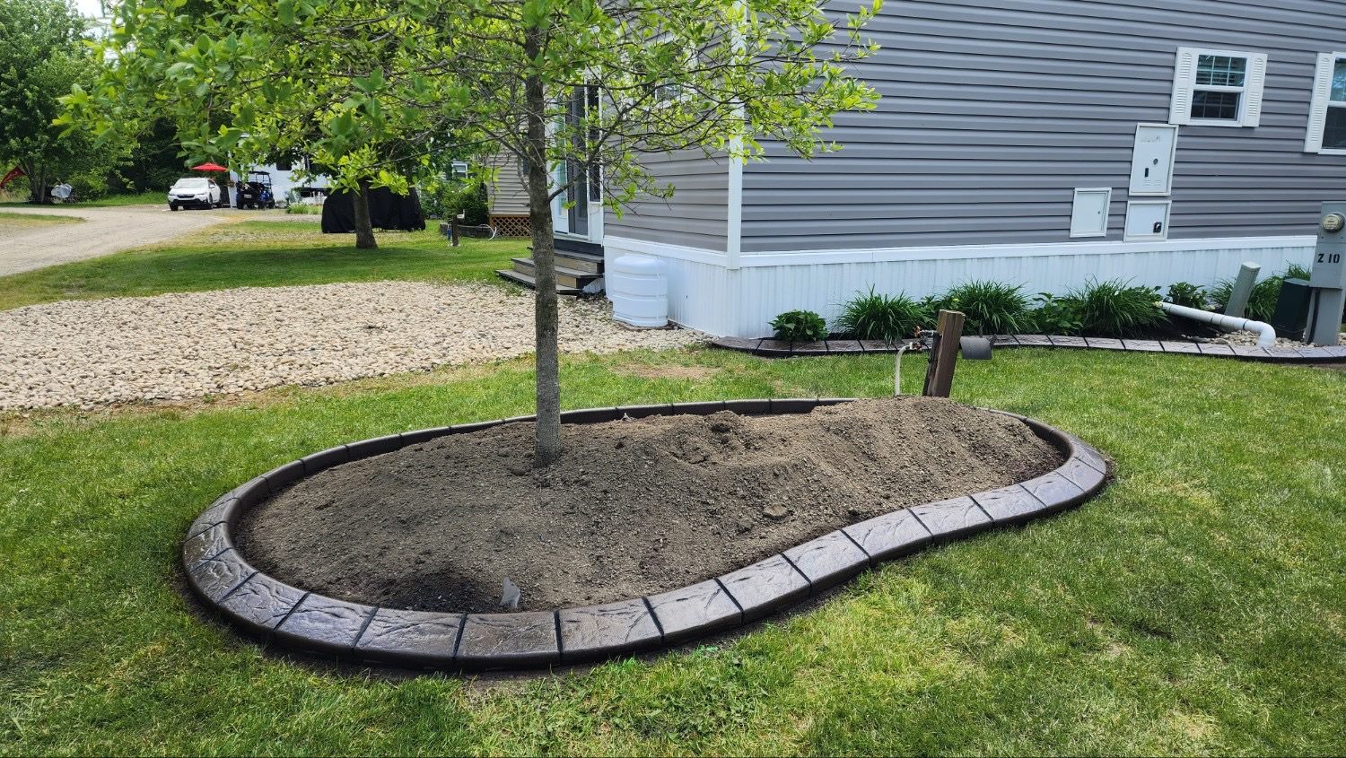 Decorative concrete curbing around a landscaped tree bed