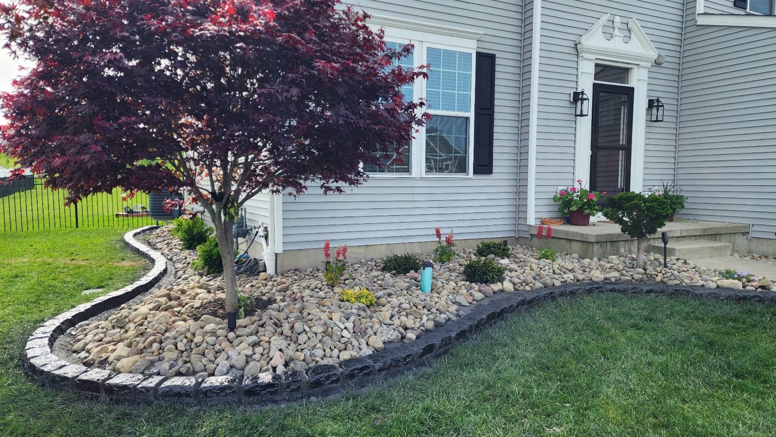Charcoal stamped decorative curbing around a river-rock bed