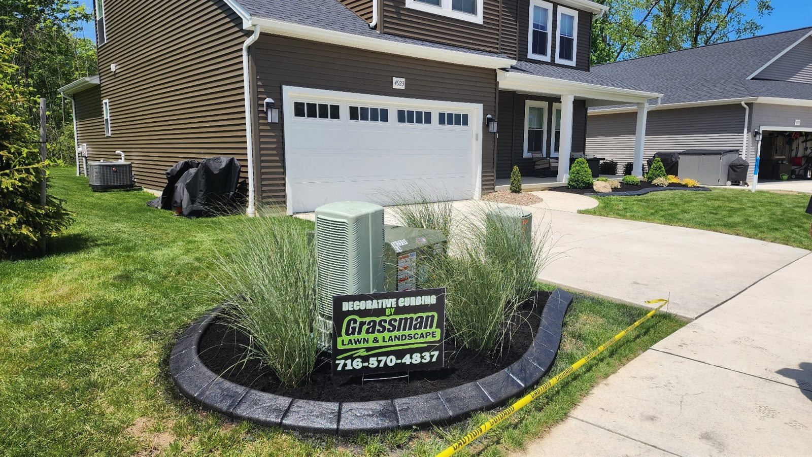 Grassman decorative curbing project with the company yard sign